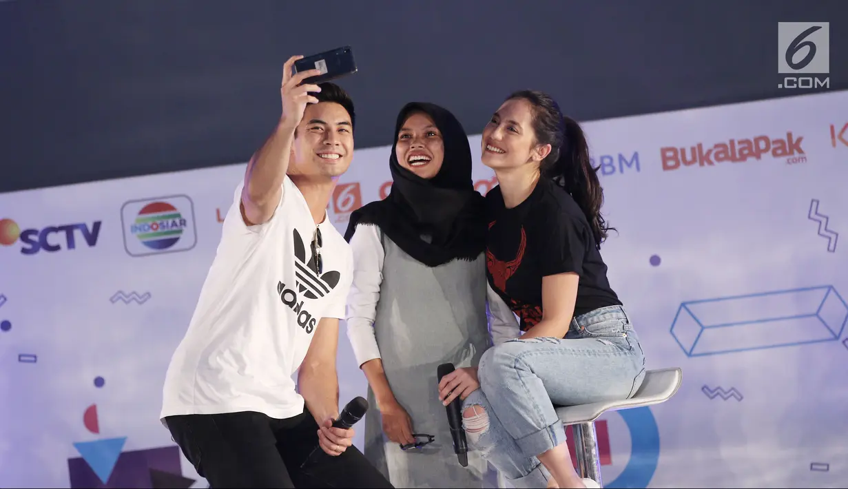 Pemain film Buffalo Boys, Pevita Pearce (kanan) bersama Yoshi Sudarso (kiri) foto bersama peserta Emtek Goes to Campus (EGTC) 2018 di Universitas Negeri Semarang (UNNES), Semarang, Kamis (19/7). (Liputan6.com/Herman Zakharia)