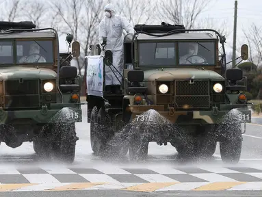 Truk-truk tentara Korea Selatan menyemprotkan desinfektan di sebuah jalan di Ulsan, Selasa (3/3/2020). Seoul mengerahkan tentara untuk menyemprotkan disinfektan di jalan dan gang-gang untuk mencegah penyebaran virus corona COVID-19. (Kim Young-tae/Yonhap via AP)