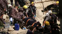 Tim penyelamat dari Pertahanan Sipil Yordania membawa seorang korban yang merupakan penghuni bangunan yang runtuh, di Amman, Yordania, Selasa (13/9/2022). Dalam insiden ini menyebabkan sedikitnya lima tewas dan tujuh lainnya terluka. (AP Photo/Raad Adayleh)