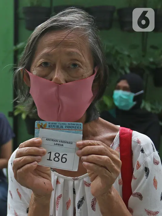 Warga lanjut usia (lansia) menunjukkan nomor antrean vaksinasi Covid-19 di Puskesmas Kecamatan Senen, Jakarta Pusat, Selasa (23/2/2021). aksinasi untuk Lansia akan dimulai di ibu kota provinsi untuk seluruh provinsi di Indonesia, di prioritaskan di Jawa-Bali. (Liputan6.com/Herman Zakharia)
