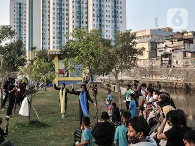 Anak-anak menyaksikan pelatihan tari saat kehadiran Perpustakaan Keliling di kawasan Kampung Melayu, Jakarta, Minggu (16/8/2020). Kegiatan sosial ini digelar oleh Komunitas Perpustakaan Jalanan Jakarta dan Rakyat Berbagi. (merdeka.com/Iqbal S. Nugroho)