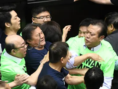 Anggota parlemen dari Partai Progresif Demokratik (DPP) berkelahi dengan Partai Nasionalis Tiongkok atau yang dikenal dengan Kuomintang (KMT) saat melakukan protes di Parlemen di Taipei (20/4). (AFP Photo/Sam Yeh)