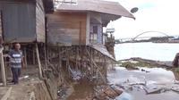 Warga melihat lokasi ablasi di bantaran Sungai Kahayan yang menghancurkan tiga unit rumah di Gang Sepakat Flamboyan Bawah Kelurahan Langkai Kecamatan Pahandut Kota Palangka Raya, Jumat (6/1/2023).