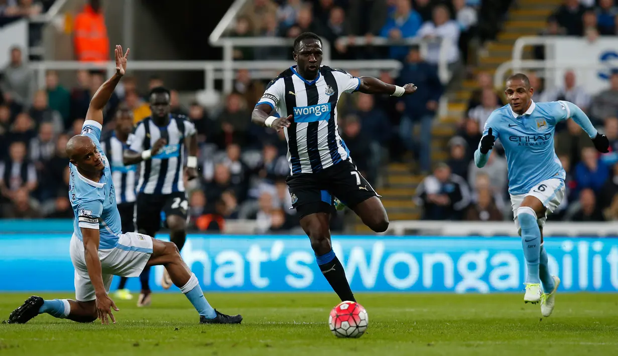 Gelandang Newcastle, Moussa Sissoko (tengah) membawa bola dari kawalan bek City, Vincent Kompany pada lanjutan liga Inggris di St James 'Park (20/4). Newcastle bermain imbang atas City dengan skor 1-1. (Reuters/Andrew Yates)