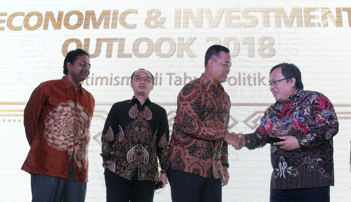 Dirut PT Danareksa Investment Management Marsangap P. Tamba memberikan cindermata kepada Menteri PPN / Kepala Bappenas Bambang Brodjonegoro pada Economic & Investment Outlook 2018 di Jakarta, Rabu (17/1). (Liputan6.com/Pool/Eko)