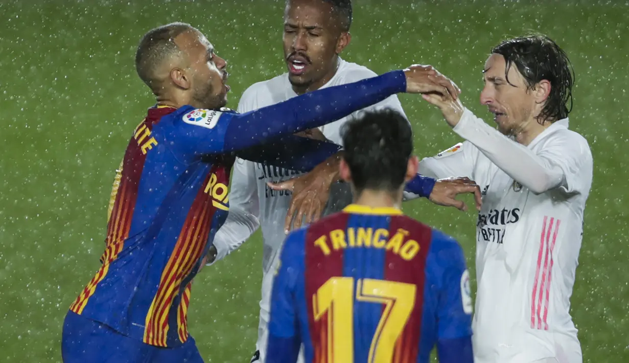 Striker Barcelona, Martin Braithwaite (kiri) terlibat pertikaian dengan gelandang Real Madrid, Luka Modric dalam laga lanjutan Liga Spanyol 2020/2021 pekan ke-30 di Alfredo di Stefano Stadium, Madrid, Sabtu (10/4/2021). Barcelona kalah 1-2 dari Real Madrid. (AP/Manu Fernandez)