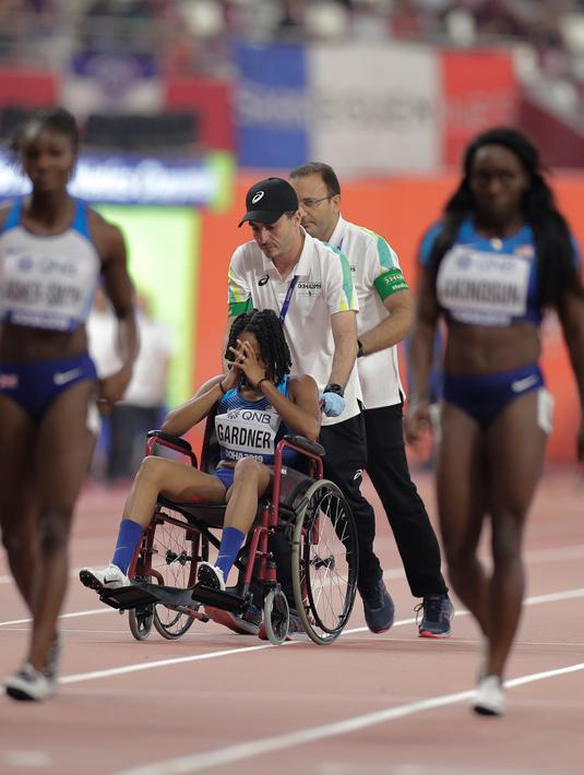 Sprinter Amerika Serikat, English Gardner menutupi wajahnya saat dibawa oleh tim medis akibat cedera dalam semifinal 100 meter putri Kejuaraan Atletik Dunia di Doha, Qatar, Minggu (29/9/2019). Peraih medali emas olimpiade tersebut mengalami cedera hamstring. (AP Photo/Petr David Josek)
