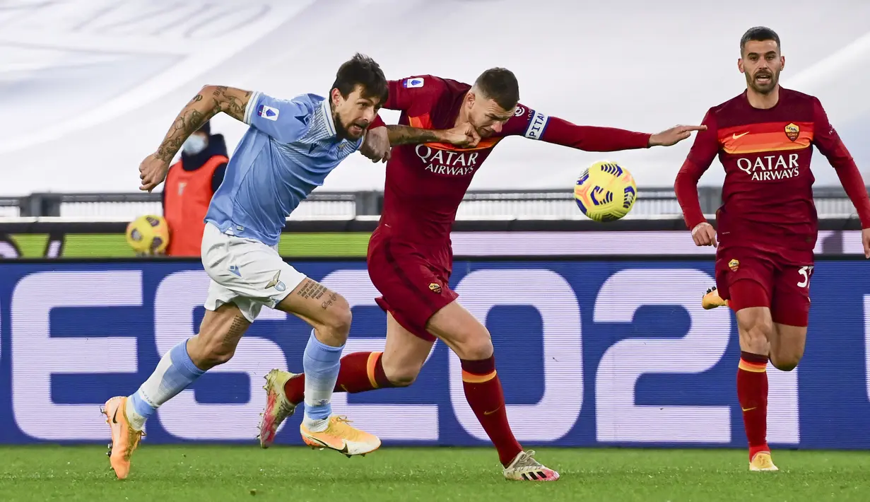 Penyerang AS Roma, Edin Dzeko dan bek Lazio, Francesco Acerbi bersaing memperebutkan bola dalam pekan ke-18 Liga Italia di Stadion Olimpiade Roma, Sabtu (16/1/2021) dini hari WIB. AS Roma dibantai 0-3 oleh Lazio dalam laga bertajuk Derby della Capitale. (AP Photo/Andrew Medichini)
