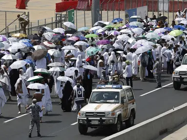 Kendaraan polisi melintas dekati ribuan umat muslim di salah satu jalan di Mina, Arab Saudi, Kamis (24/9/2015). Sekitar 310 jemaah wafat akibat berdesak-desakan saat prosesi lempar jumrah di Mina. (REUTERS/Ahmad Masood)