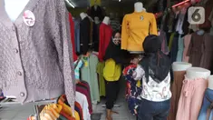 Warga membenahi  display  busana pada sebuah toko di sentra konveksi Bulak Timur, Depok, senin (11/5/2020). Jelang Lebaran 2020, pembuat dan penjual konveksi di kawasan ini mengeluhkan anjloknya penjualan hingga 80% hingga 90% akibat dampak pandemi Covid-19. (merdeka.com/Arie Basuki)