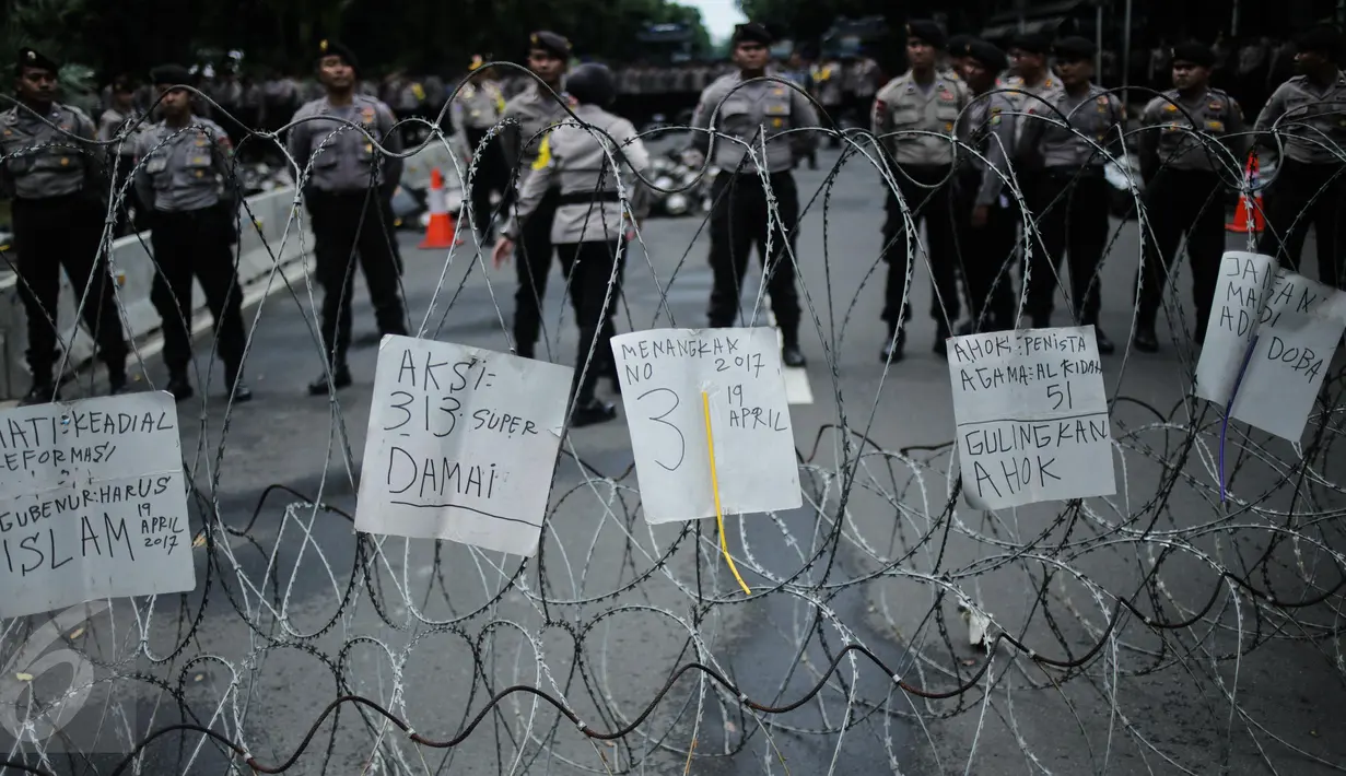 Petugas berjaga saat aksi bela islam 313 di kawasan Jalan Merdeka Barat, Jakarta, Jumat (31/3). Mereka menuntut kepada Presiden Jokowi agar melaksanakan undang-undang dengan mencopot gubernur terdakwa, Ahok. (Liputan6.com/Faizal Fanani)