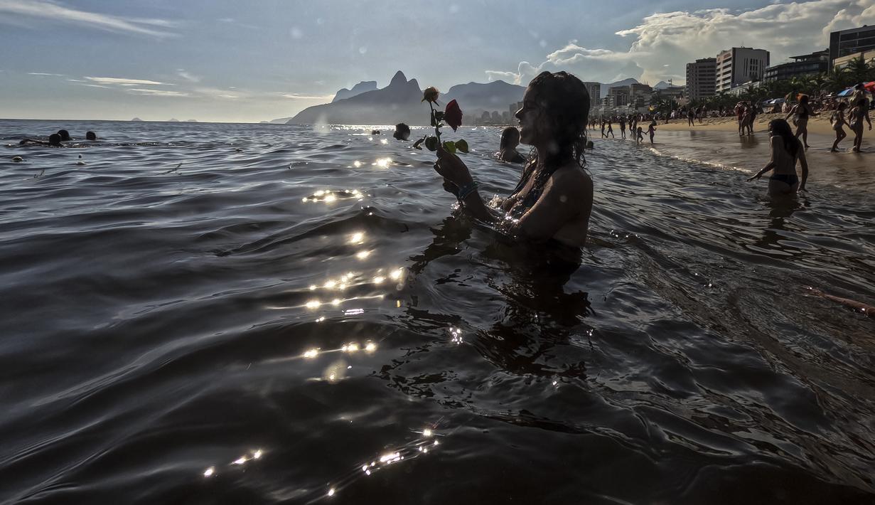 Pemuja dewi laut Yemanja menempatkan persembahan bunga di perairan pantai Arpoador selama perayaan tahunan di Rio de Janeiro, Brasil, Kamis, 2 Februari 2023. Dalam kepercayaan Afro-Brasil, Yemanja diyakini sebagai representasi dewi laut yang cantik jelita. (AP Photo/Bruna Prado)