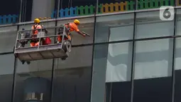 Pekerja membersihkan kaca gedung bertingkat di kawasan Jakarta, Kamis (2/4/2020). Dari 128 juta angkatan kerja di Indonesia, hanya 39% atau 50 jutaan pekerja yang terlindungi jaminan sosial ketenagakerjaan. (Liputan6.com/Herman Zakharia)
