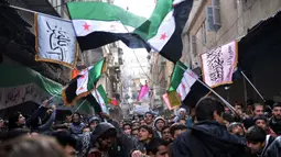 Pengunjuk rasa antirezim Suriah mengibarkan bendera Suriah pra-Baath, yang sekarang digunakan oleh Tentara Pembebasan Suriah, selama demonstrasi setelah salat Jumat di Distrik Bustan al-Qasr, Aleppo, Suriah, 8 Februari 2013. (Photo by AAMIR QURESHI/AFP)