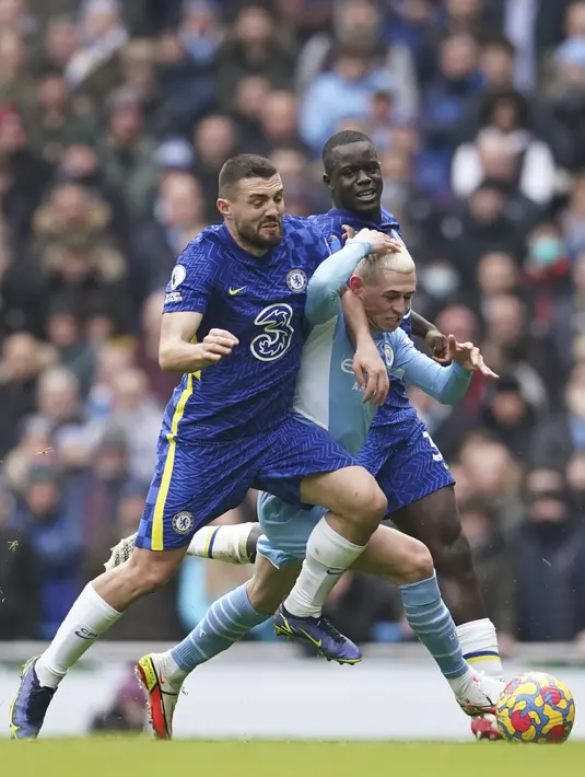 Gelandang Chelsea, Mateo Kovacic (kiri) berebut bola dengan gelandang Manchester City, Phil Foden pada pertandingan lanjutan Liga Inggris di stadion Etihad di Manchester, Inggris, Sabtu (15/1/2022). Man City menang tipis atas Chelsea 1-0. (AP Photo/Dave Thompson)