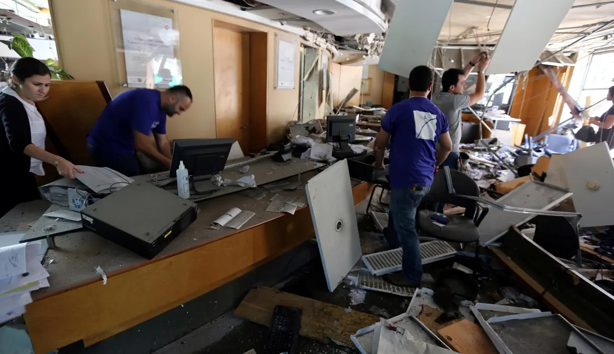 Warga dan petugas saat memeriksa kerusakan yang terjadi di Bank Blom pasca ledakan di Beirut, Lebanon (13/6). Bom meledak di sekitar Bank Blom pada Minggu (12/6) malam.( REUTERS/Aziz Taher)