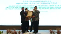 Direktur Operasional MURI, Yusuf Ngadri menyerahkan penghargaan kepada Gubernur Jawa Barat Ridwan Kamil dan Direktur Kepesertaan BPJS Ketenagakerjaan (BPJAMSOSTEK) Zainudin di Bandung, Senin (30/8).