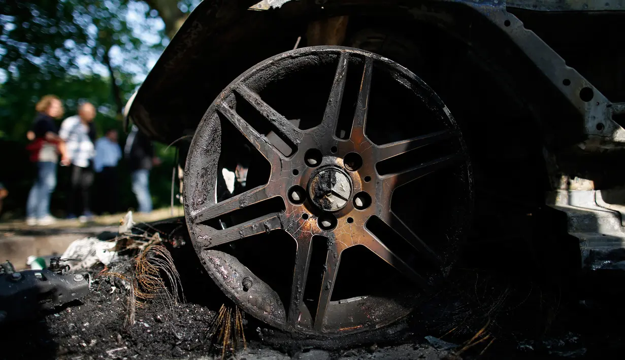 Ban mobil yang hangus terbakar usai aksi demo menentang KTT G20 di Hamburg, Jerman utara, (7/7). Para demonstran bentrok dengan polisi dan membakar mobil patroli dalam kekerasan baru menjelang KTT G20. (AFP Photo/Ronny Hartmann)