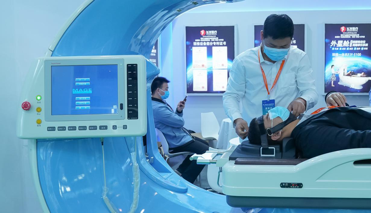Peserta pameran mengoperasikan perangkat medis yang ditampilkan dalam Pameran Kesehatan Dunia Kedua di Wuhan, Provinsi Hubei, China pada 11 November 2020. Ajang selama empat hari itu berfokus memamerkan ilmu pengetahuan dan teknologi mutakhir dalam industri kesehatan global. (Xinhua/Cheng Min)