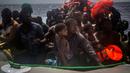 Sejumlah imigran menunggu di atas perahu karet untuk diselamatkan di lepas pantai Libya, Selasa (25/7). Kapal penyelamat kemanusiaan milik LSM asal Spanyol, Proactiva Open Arms, menemukan 13 jasad di atas perahu karet tersebut. (AP/Santi Palacios)