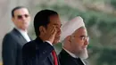 Presiden Joko Widodo bersama Presiden Hassan Rouhani saat mengikuti upacara penghormatan di Istana Saadabad, Rabu (14/12). Pemerintah Indonesia dan Iran sepakat meningkatkan kerja sama di bidang energi dan migas. (AFP Photo/Atta Kenare)