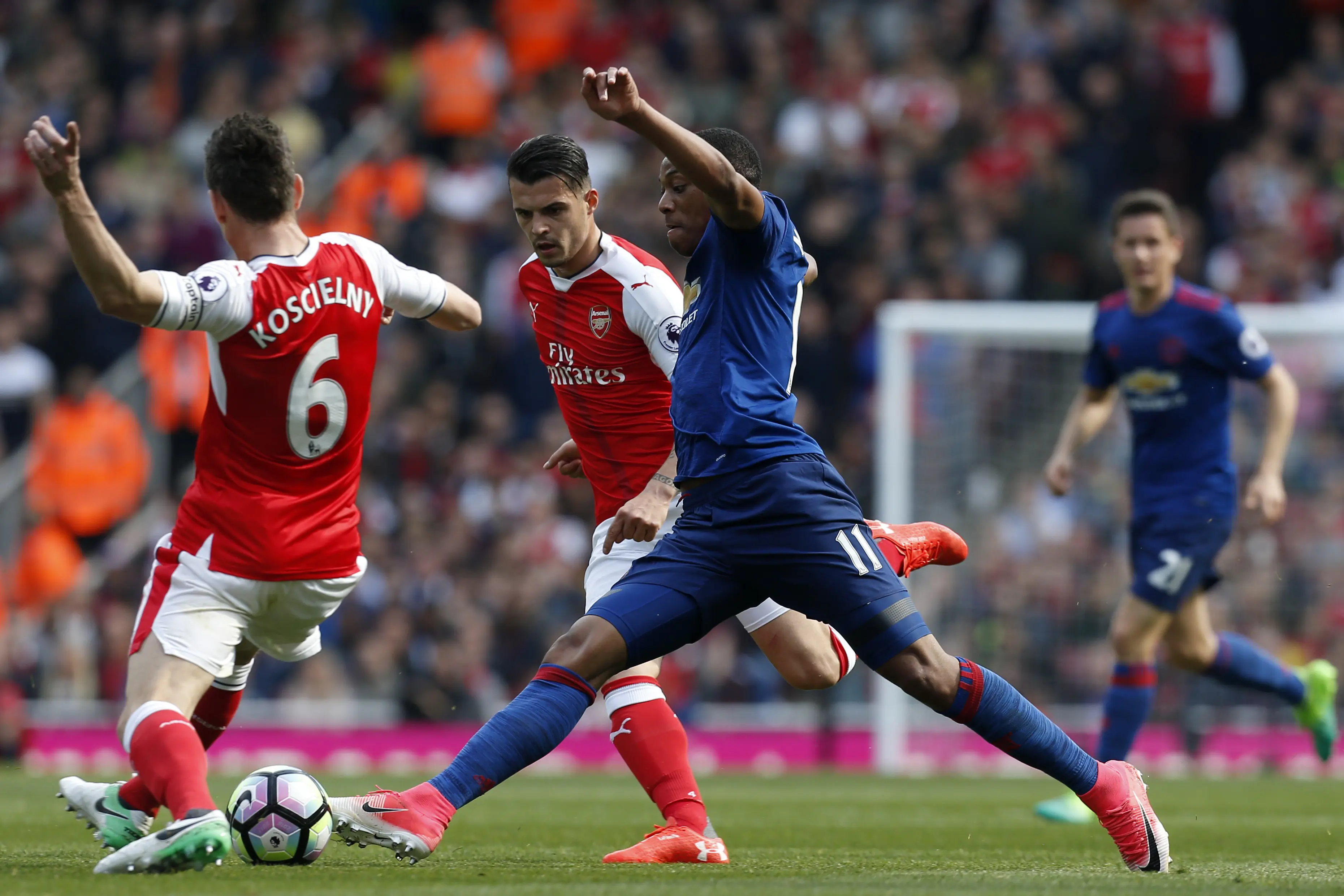 Penyerang Manchester United (MU), Anthony Martial saat mencoba untuk melewati dua pemain Arsenal. (Ian KINGTON / IKIMAGES / AFP)