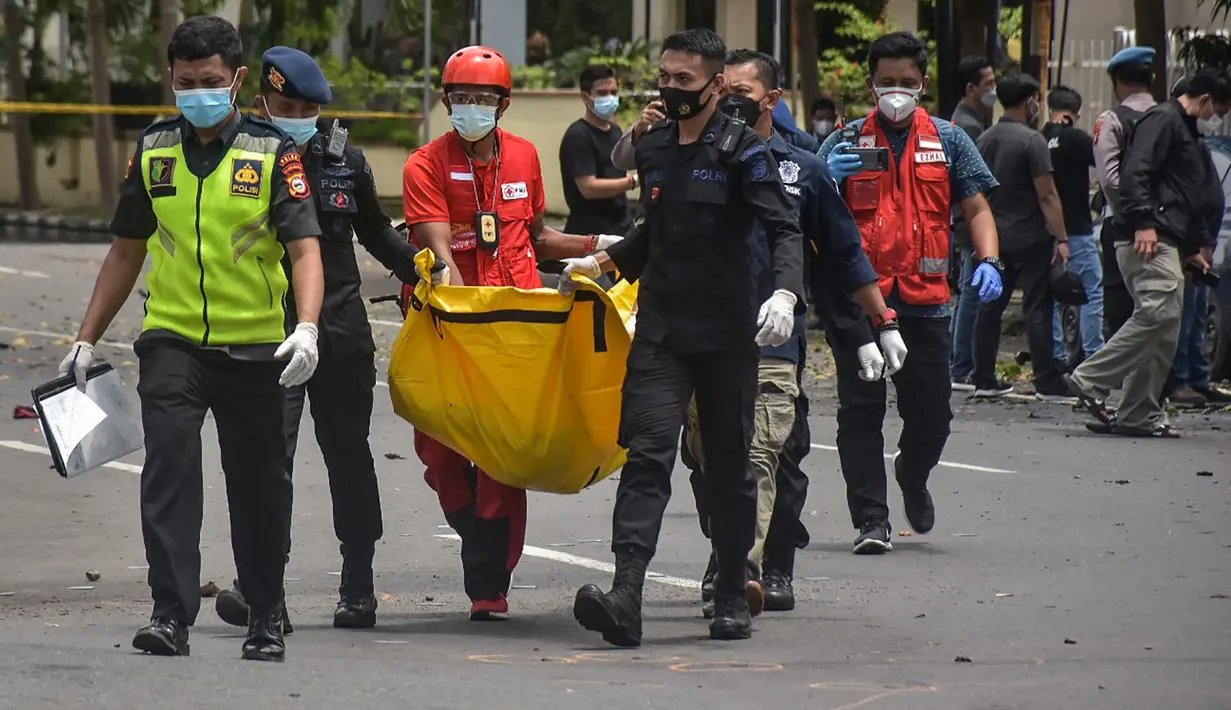 Polisi membawa tas berisi jenazah tersangka pelaku bom bunuh diri setelah ledakan di luar sebuah gereja di Makassar (28/3/2021). Kapolda Sulsel Irjen Merdisyam menduga, ledakan yang terjadi di Gereja Katedral Makassar diduga akibat bom bunuh diri. (AFP/Indra Abriyanto)