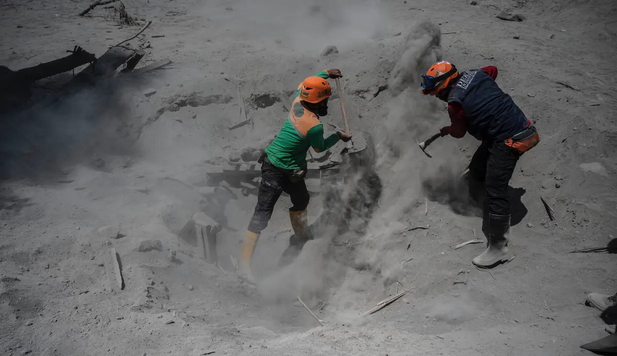 Tim penyelamat melakukan pencarian korban di rumah yang terkubur abu vulkanik letusan Gunung Semeru di Desa Sumber Wuluh, Lumajang, Jawa Timur, Selasa (7/12/2021). Letusan Gunung Semeru menewaskan sedikitnya 34 orang. (AFP/Juni Kriswanto)