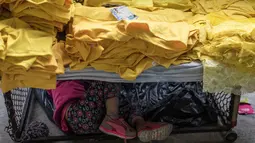 Sebuah keluarga memilih celana dalam berwarna kuning untuk dipakai pada perayaan tahun baru di Medellin, Kolombia, Jumat (29/12). Selain di Kolombia, tradisi unik ini sudah lama dianut oleh warga beberapa negara di Amerika. (Joaquin SARMIENTO / AFP)