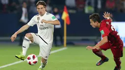 Gelandang Real Madrid, Luka Modric mengontrol bola dari kawalan pemain Kashima Antlers, Abe Hiroki selama semifinal Piala Dunia Antarklub 2018 di stadion Zayed Sports City, Uni Emirat Arab (19/12). Madrid menang 3-1. (AP Photo/Kamran Jebreili)