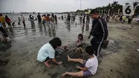 Pengunjung bermain di Pantai Karnaval Ancol, Jakarta, Jumat (14/5/2021). Pemprov DKI Jakarta pada libur Lebaran 2021 membuka sejumlah tempat wisata, salah satunya Ancol. (Liputan6.com/Johan Tallo)