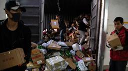 Para pekerja ekspedisi sibuk memilah paket untuk dikirim ke pelanggan saat Singles Day di Beijing, China, Senin (11/11/2019). Singles Day menjadi pesta belanja online terbesar di dunia. (NOEL CELIS/AFP)