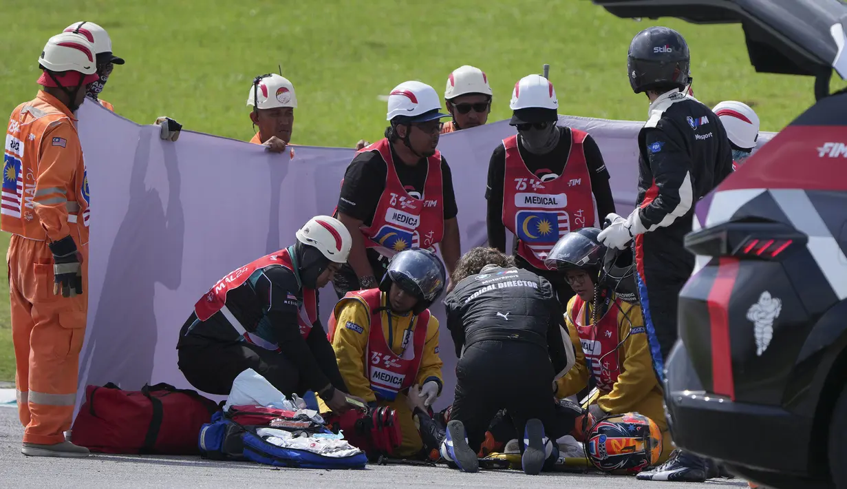 Pembalap KTM, Jack Miller mendapatkan perawatan dari petugas medis setelah terjatuh saat ajang balap MotoGP Malaysia 2024 yang berlangsung di Sirkut Sepang, Malaysia, Selasa (05/11/2024). (AP Photo/Vincent Thian)