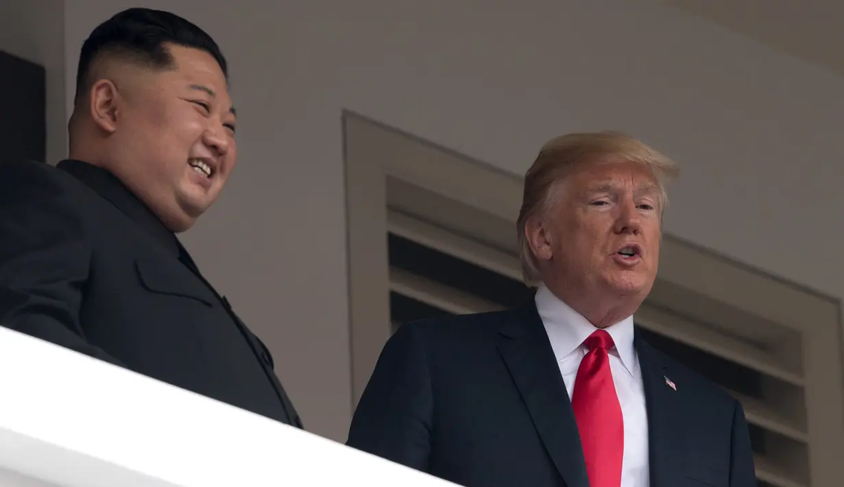 Ekspresi Presiden AS Donald Trump (kanan) dan Pemimpin Korea Utara Kim Jong-un saat tampil di balkon Hotel Capella, Pulau Sentosa, Singapura, Selasa (12/6). Trump dan Kim optimis bahwa KTT akan sukses. (SAUL LOEB/AFP)