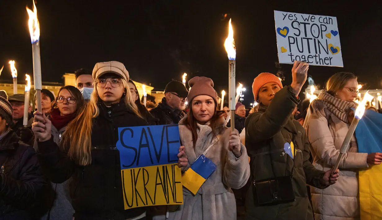 Wanita memegang spanduk saat demonstrasi untuk Ukraina yang diselenggarakan oleh Greenpeace di Heroes Square, Budapest, Hungaria, 9 Maret 2022. Lebih dari 1,5 juta orang telah menyeberang dari Ukraina ke negara-negara tetangga. (AP Photo/Anna Szilagyi)