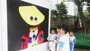 Siswa SD Negeri Menteng 01 mengamati karya foto yang dipamerkan dalam pameran fotografi Rekam Jakarta di Taman Menteng, Kamis (29/8/2019). Kegiatan tersebut dalam rangka edukasi bagi siswa mengenal profesi foto jurnalistik. (Liputan6.com/Marsha Aulia)