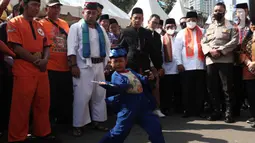 Seorang anak menampilkan pertunjukan kesenian bela diri asli Betawi Palang Pintu dalam Lebaran Tenabang 2022 di kawasan Tanah Abang, Jakarta, Sabtu (4/6/2022). Kegiatan yang menampilkan berbagai kesenian Betawi, makanan tradisional, perlombaan, dan bazar UMKM itu mengangkat tema KolaborAksi. (Liputan6.com/Angga Yuniar)