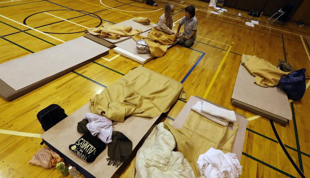Pengungsi dari Topan Hagibis beristirahat di gym sekolah dasar terdekat di Kota Kawagoe, Jepang (14/10/2019). Sedikitnya 43 orang tewas akibat dilandan Topan Hagibis. (AP Photo/Eugene Hoshiko)