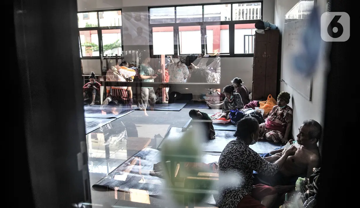 Aktivitas warga korban banjir saat mengungsi di salah satu ruang kelas SDN 01 Kampung Melayu, Jakarta, Minggu (21/2/2021). Selama pandemi virus corona, pihak kelurahan menyiapkan pengungsian di lantai 1 dan 2 serta membatasi 50 persen kapasitas pengungsi. (merdeka.com/Iqbal S Nugroho)