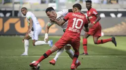 Pemain Bayer Leverkusen, Kerem Demirbay, berusaha menghadang pemain Borussia Moenchengladbach, Ramy Bensebaini, pada laga Bundesliga, Minggu (24/5/2020). Bayer Leverkusen menang 3-1 atas Borussia Moenchengladbach. (AFP/Ina Fassbender)