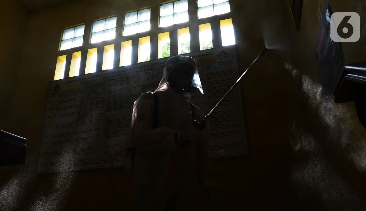 Petugas PMI menyemprotkan cairan disinfektan di Lingkungan SMP Negeri 139 Jakarta, Selasa (9/6/2020). Penyemprotan untuk mencegah penyebaran virus Corona di lingkungan sekolah itu sebagai persiapan memasuki tahun ajaran baru 2020/2021. (merdeka.com/Imam Buhori)
