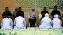 Orang-orang yang dinyatakan bersalah melanggar hukum Islam, di antaranya pasangan yang belum menikah yang terbukti berciuman saat siaran langsung TikTok, menunggu giliran untuk dicambuk di depan umum di Taman Bustanussalatin, Banda Aceh, Aceh, Kamis (2/7/2026). (AP Photo/Reza Saifullah)