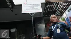 Seorang petugas berdiri di depan plang segel sebuah rumah toko (ruko) yang berada di Wijaya Grand Center, Jakarta Selatan, Senin (28/11). Ruko tersebut masuk dalam daftar kekayaan Nazaruddin yang dirampas negara. (Liputan6.com/Helmi Affandi)