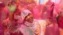 Seorang janda India dengan kerudung bertabur bubuk berwarna-warni saat mengikuti perayaan Holi di kota Vrindavan, India, (9/3). Para janda India dulunya dilarang menghadiri perayaan holi. (AFP Photo / Dominique Faget)