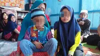 YAN (65), mendampingi kedua cucunya saat berada di samping jenasah anaknya BS (36), yang meninggal dunia dianiaya temannya di Palembang (Liputan6.com / Nefri Inge)