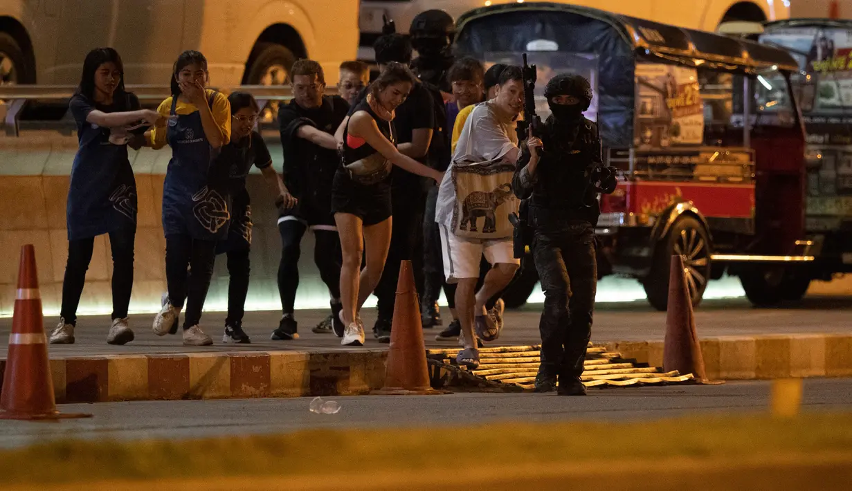Tentara mengawal pengunjung yang keluar dari mal Terminal 21 Korat saat terjadi penembakan di Nakhon Ratchasima, Thailand, Minggu (9/2/2020). Akibat penembakan tersebut sebanyak 20 orang tewas. (AP Photo/Sakchai Lalitkanjanakul)