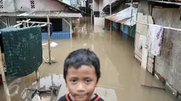 Seorang anak berada di kawasan Cawang, Jakarta, Selasa (21/2). Akibat curah hujan yang tinggi sejumlah pemukiman di bantaran Ciliwung kelurahan Cawang dan Rawajati terendam banjir. (Liputan6.com/Yoppy Renato)