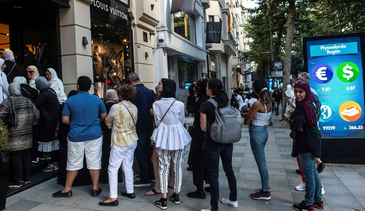 Turis asing, terutama dari Arab Saudi, mengantre di luar toko barang mewah Louis Vuitton di Istanbul, 13 Agustus 2018. Para turis memborong banyak barang-barang mewah, sebelum penjual menaikkan harga untuk memperhitungkan devaluasi lira. (AFP/Yasin AKGUL)