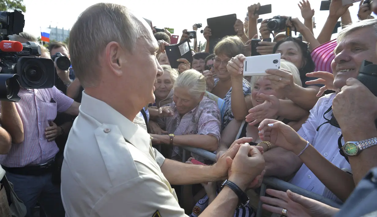 Presiden Rusia Vladimir Putin menyapa sejumlah warga usai menjajal kapal selam mini memasuki perairan Laut Hitam saat ekspedisi di Sevastopol, Crimea, Rusia, Selasa (18/8/2015). (REUTERS/Alexei Nikolsky/RIA Novosti/Kremlin)