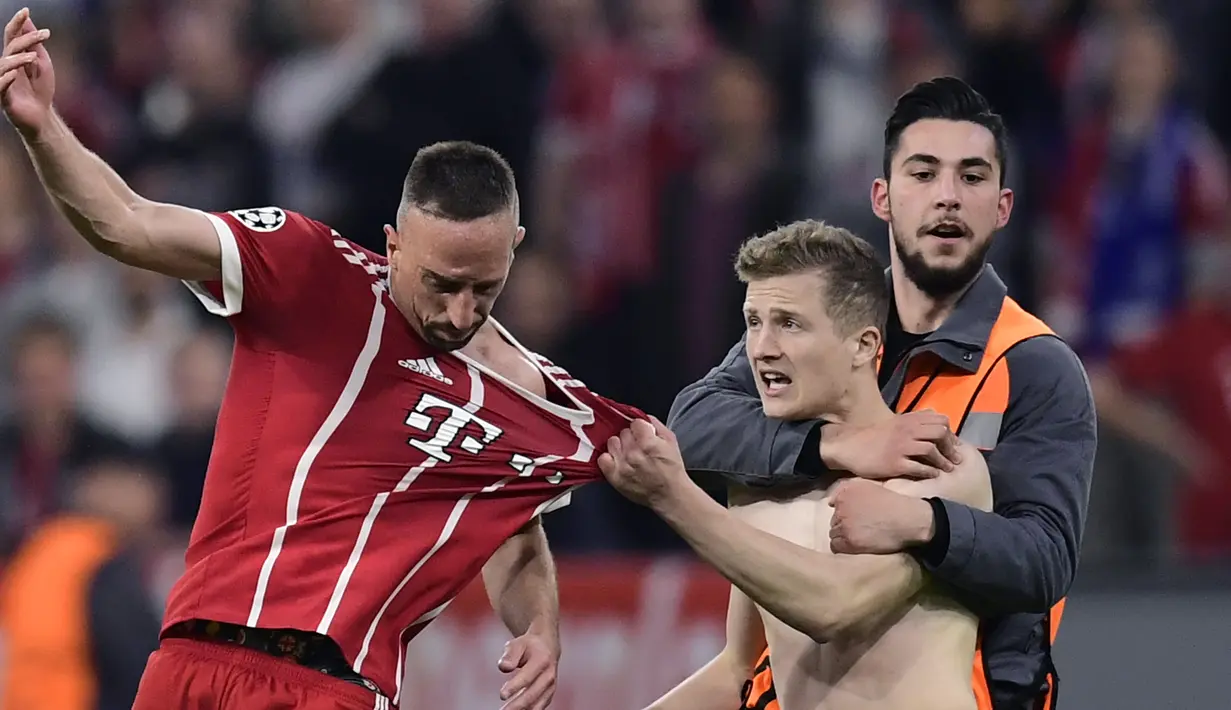 Seorang penyusup lapangan menarik baju Franck Ribery gelandang Bayern Munich pada semifinal leg pertama UEFA Champions League melawan Real Madrid pada 2018 lalu. ( AFP/Javier Soriano )